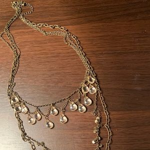 Gold tone long charm necklace